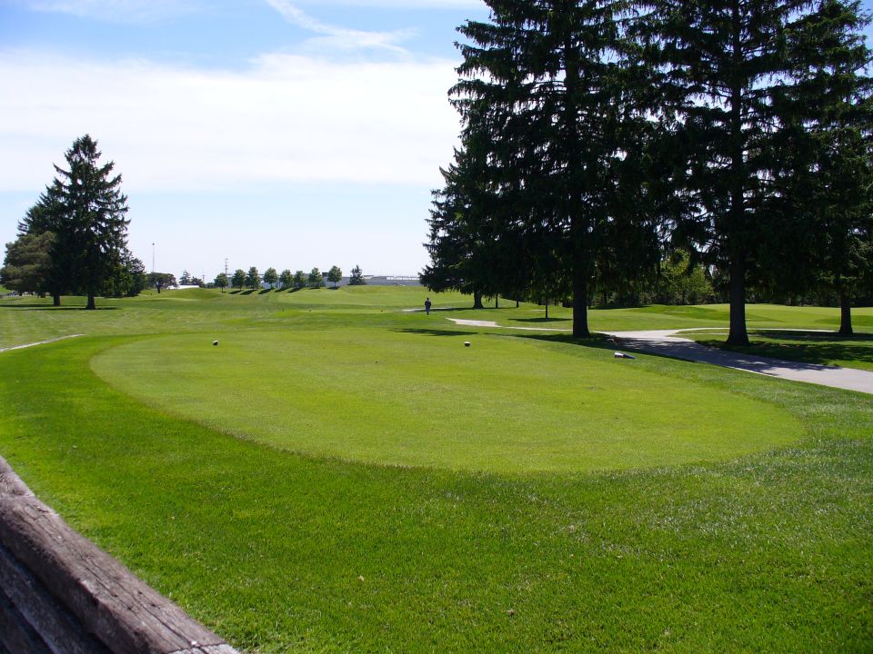 Golf course with green grass, trees, and a path