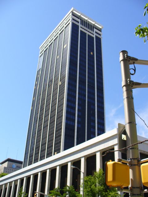 1991 Ford Probe - A large office building dominates the skyline under a clear blue sky, with traffic signals visible in the foreground.