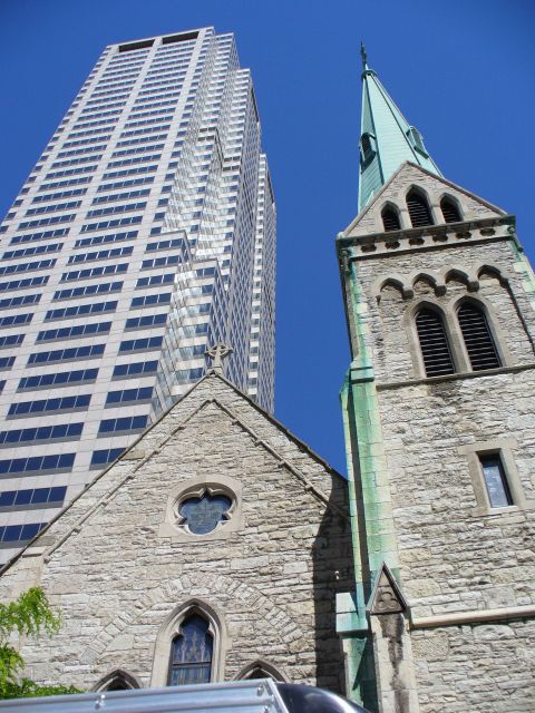 1991 Ford Probe - A stone church with a green steeple stands next to a tall, modern skyscraper under a clear blue sky.