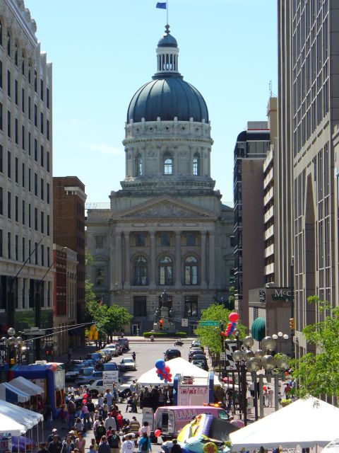 1991 Ford Probe - A busy street fair unfolds in front of a grand capitol building, with many people and vehicles present.