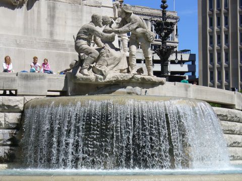 1991 Ford Probe - A monument with a fountain is seen with people relaxing nearby on a sunny day.