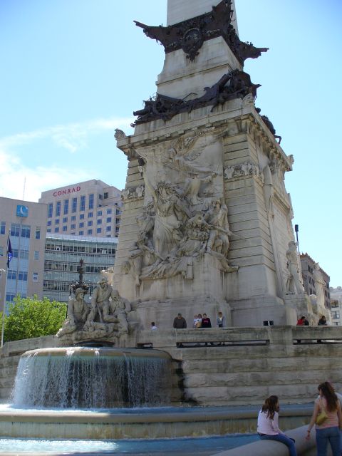 1991 Ford Probe - Monument with fountain and city buildings under a blue sky.