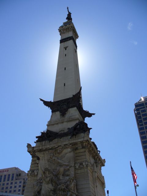 1991 Ford Probe - A tall monument stands against the sun, with a skyscraper in the background.