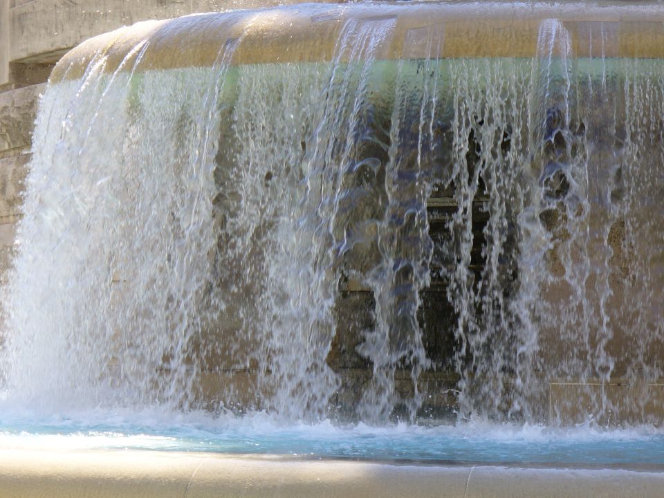 Waterfall cascading over stone structure with SuperMotors logo