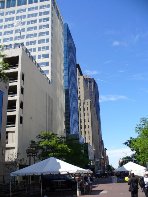 1991 Ford Probe - A city street is lined with tall buildings and features white tents and people on a clear day.