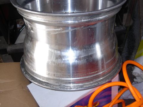 1994 Ford Bronco - Close-up of a damaged aluminum wheel rim, with an orange hose visible.