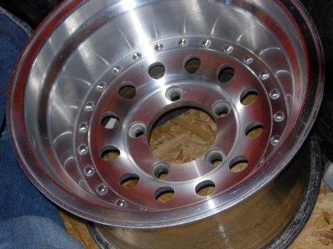 1994 Ford Bronco - A close-up view of a polished aluminum wheel with a multi-lug pattern is shown.