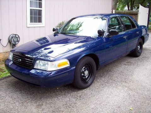 1998 Lincoln Town Car - A blue 1998 Lincoln Town Car is parked in front of a house.