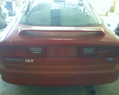 1993 Ford Probe - The rear of a red 1993 Ford Probe GT is visible, showing the spoiler and GT badging.