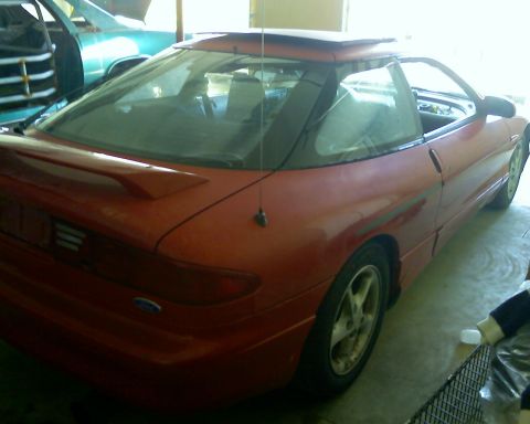 1993 Ford Probe - This red 1993 Ford Probe coupe is seen from a 3q-front angle, a prominent rear spoiler and a sunroof.