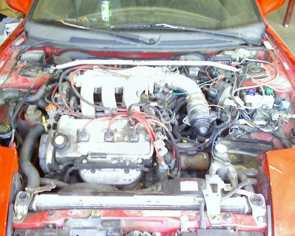 engine bay with hoses, wires, and engine components visible