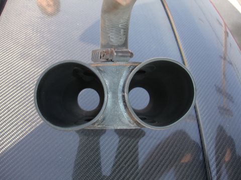 1992 Ford F-350 - Close-up of a dual exhaust tip, likely an aftermarket part, on a carbon fiber surface.