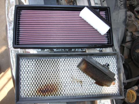 1992 Ford F-350 - A new K&N air filter is shown next to an old, dirty air filter, likely during a vehicle maintenance task.