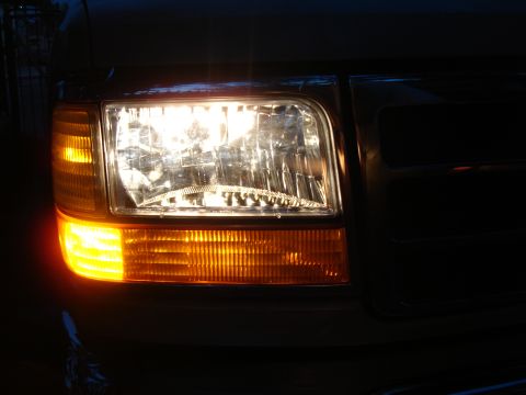 1992 Ford F-350 - Close-up of the illuminated headlight and amber turn signal on a 1992 Ford F-350 truck.