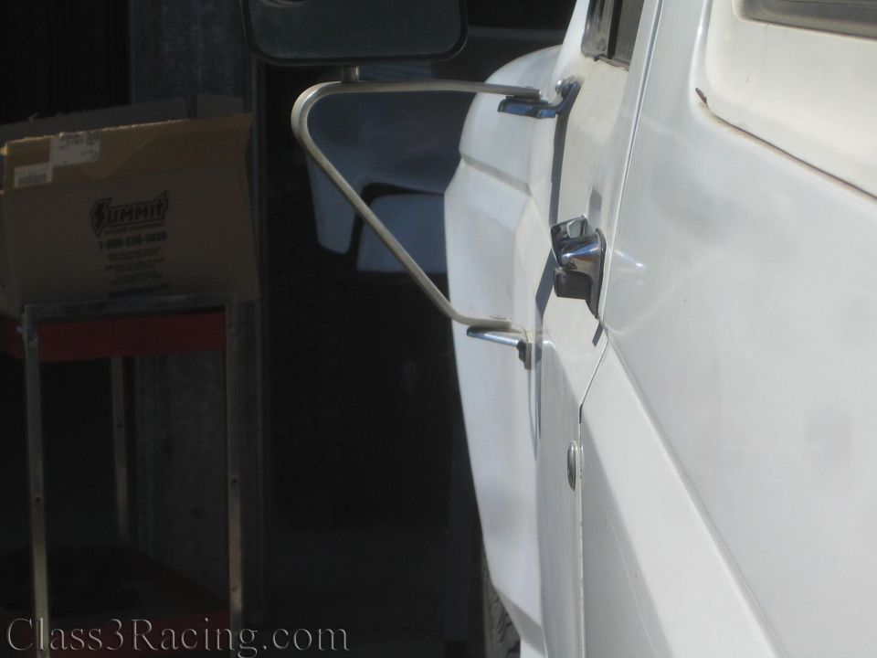 Tubular mirror bracket and door area of a white truck in a shop with a Summit box