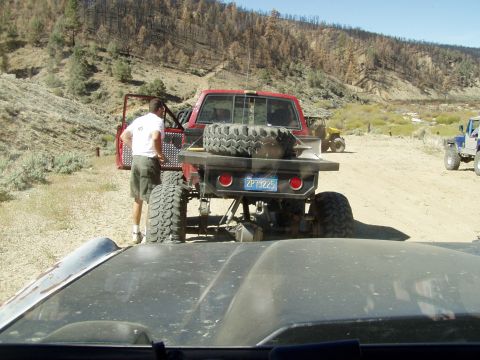 1967 Ford Bronco - Several off-road vehicles are parked in a dry, hilly landscape.