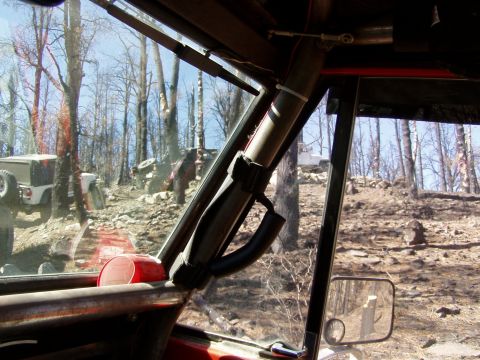 1967 Ford Bronco - Multiple off-road vehicles navigate a challenging rocky terrain, viewed from inside one of the vehicles.