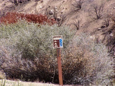 1967 Ford Bronco - Trail sign indicating routes for motorcycles and ATVs in a dry, hilly landscape.