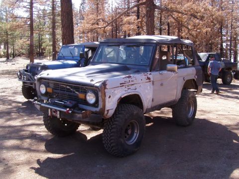 1967 Ford Bronco - This 1967 Ford Bronco, seen in a wooded area, features off-road tires and a modified front bumper.