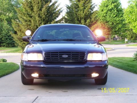 2003 Ford Crown Victoria - A dark blue 2003 Ford Crown Victoria is shown from the front on a sunny day.