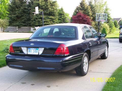 2003 Ford Crown Victoria - Rear view of a dark blue 2003 Ford Crown Victoria, parked on a concrete driveway.