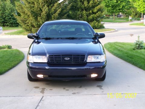 2003 Ford Crown Victoria - Frontal view of a dark blue 2003 Ford Crown Victoria parked on a concrete driveway.