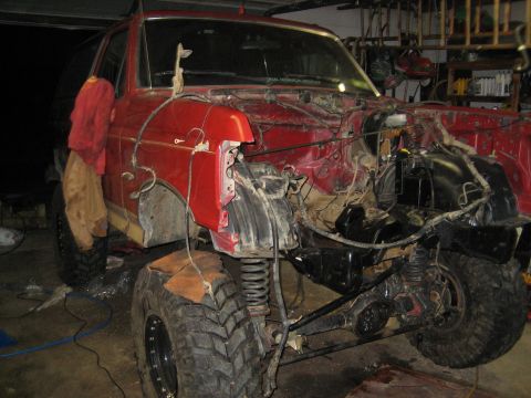 1990 Ford Bronco - This red Ford Bronco is undergoing repairs, with its front end completely dismantled.