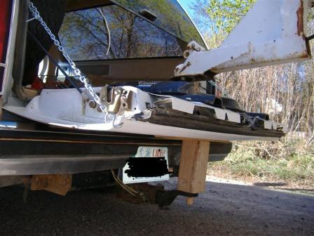 1990 Ford Bronco - The tailgate of a vehicle is open and undergoing repair, with a chain and wooden block providing support.