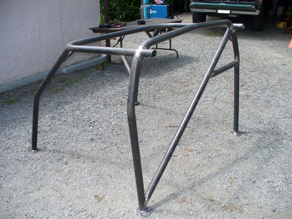 Bare welded tubular roll cage frame on gravel driveway