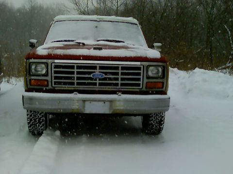 1901 Honda Odyssey - A red Ford F-Series truck sits parked in the snow during winter weather.