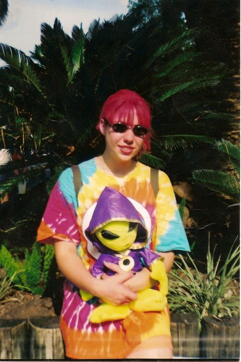 1995 Ford Bronco - A person in a colorful tie-dye shirt holds a stuffed alien toy in front of lush greenery.