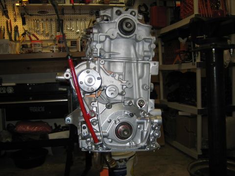 1987 Suzuki Samurai - A silver engine block is shown in a workshop setting, with tools and storage shelves visible.