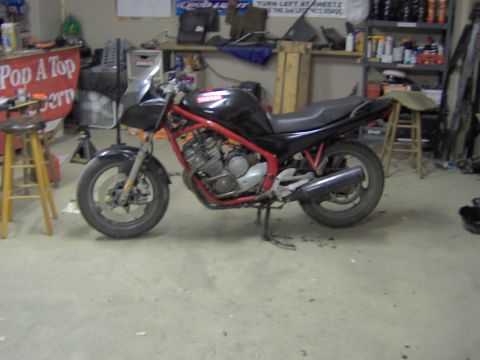1993 Yamaha Seca II - A black motorcycle with a red frame is parked in a garage, with various items on shelves in the background.
