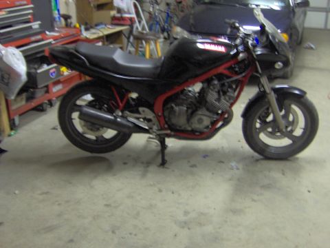 1993 Yamaha Seca II - A black Yamaha motorcycle with a red frame is parked in a garage next to a car.