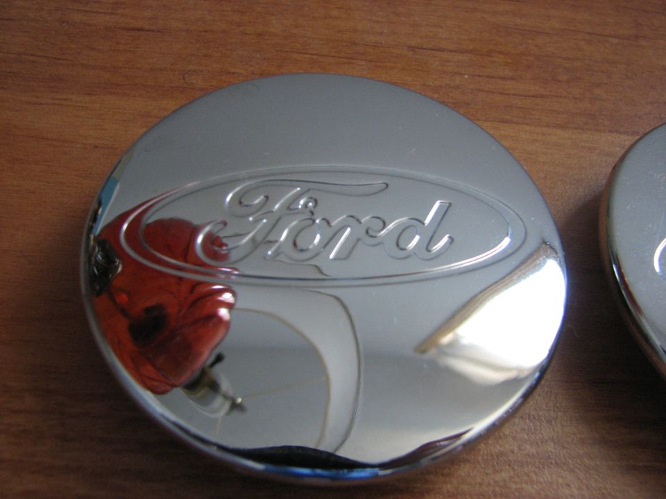 Close-up of a chrome Ford hubcap with the Ford logo embossed