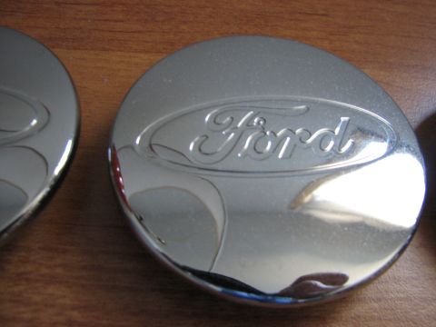 2003 Ford Crown Victoria - Close-up of a chrome Ford hubcap, showing the embossed Ford logo.