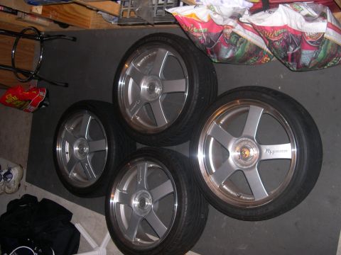 1997 Ford Probe - Four alloy wheels with tires are displayed on a floor, with one wheel showing text.