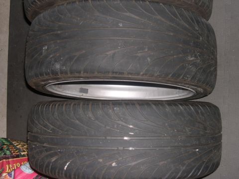 1997 Ford Probe - Two tires are stacked on top of each other, showing their tread patterns and silver rims.