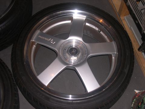 1997 Ford Probe - A single aftermarket wheel with a tire is shown, with other tires visible in the background.