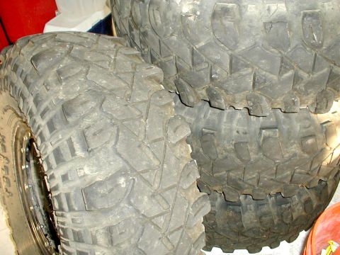 1996 Ford Bronco - A close-up view of several stacked off-road tires, with one tire prominently displayed in the foreground.