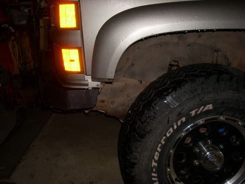 2000 Chevrolet Tahoe - A close-up view of a vehicle's front corner, showing the fender, turn signal, and a tire.
