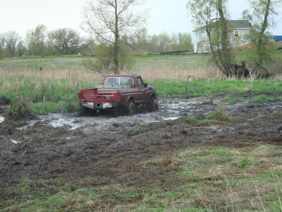 Red pickup truck stuck in a muddy field