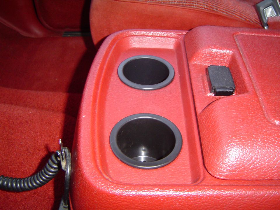Red truck center console with two cup holders and a switch
