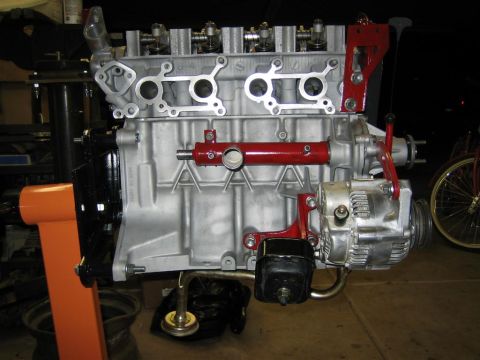 1987 Suzuki Samurai - Engine assembly, possibly for a Suzuki Samurai, is mounted on an orange engine stand.