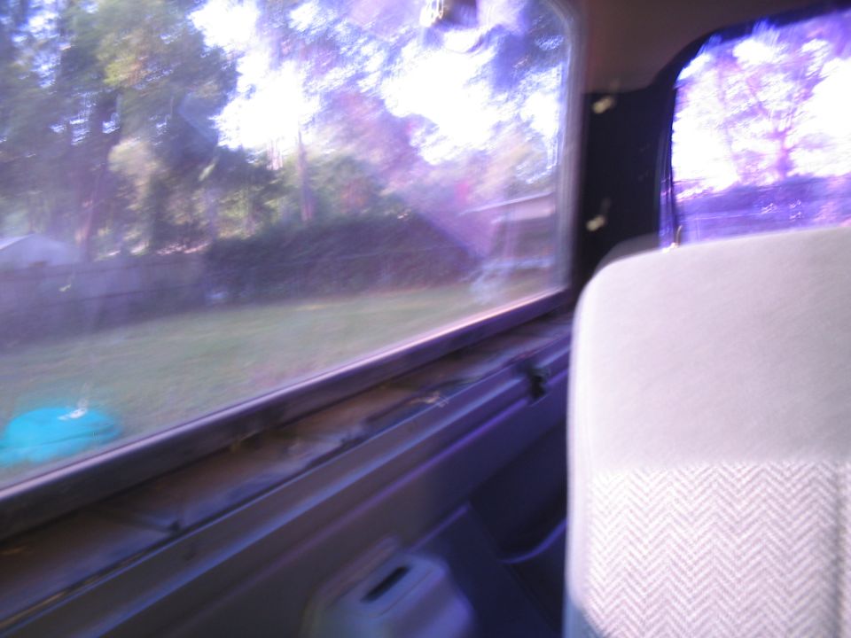 Interior view from passenger seat looking out window, showing fabric seat and door panel