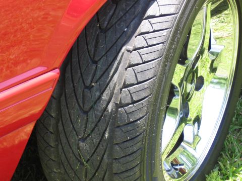 1967 Ford Mustang - Detail shot of a tire and wheel assembly on a red vehicle.