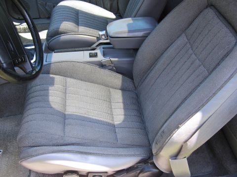 1967 Ford Mustang - Interior view of a car's front seats and dashboard area, showing gray upholstery and a center console.