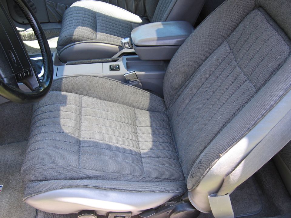 Gray fabric car seats and center console with a black steering wheel. A watermark reads "SUPERMOTORS www.supermotors.net"