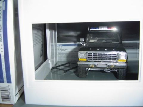 1979 Ford Bronco - A model of a 1979 Ford Bronco, possibly a police vehicle, is displayed inside a white frame.