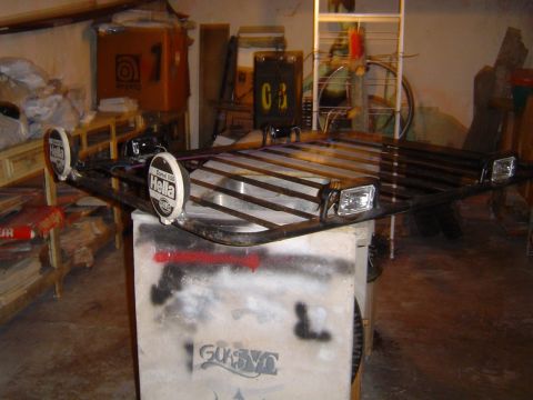 1996 Ford Explorer - Aftermarket roof rack with auxiliary lights and headlights is displayed on a concrete block.